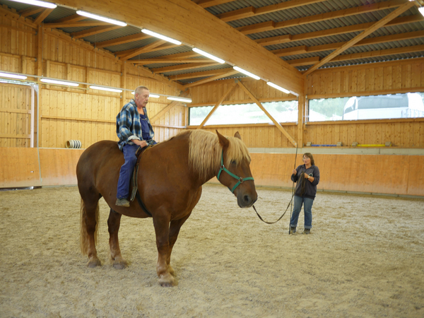 Bewohner auf einem Pferd in Reithalle - Bewohner arbeiten im Heu - Immanuel Therapiezentrum Röthof in Schmalkalden Bewohner auf einem Pferd in Reithalle - Bewohner arbeiten im Heu - Immanuel Therapiezentrum Röthof in Schmalkalden